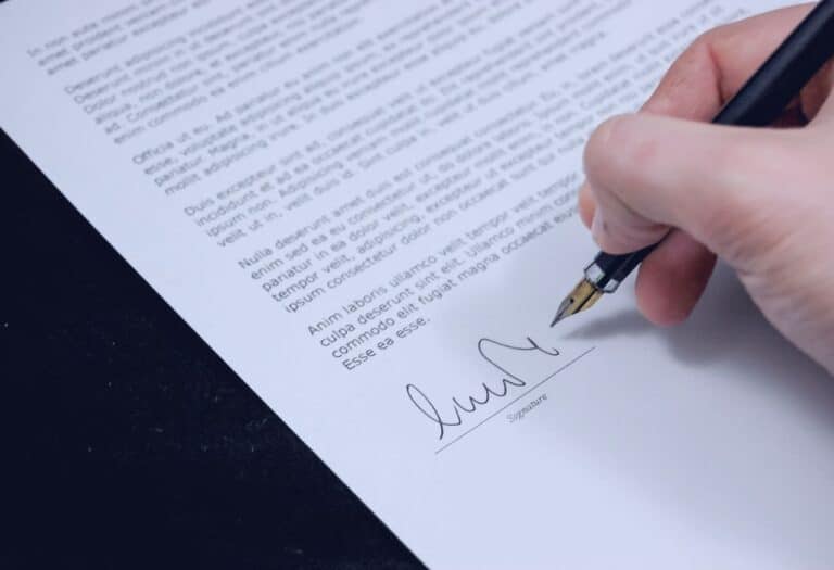 Uma imagem de uma pessoa assinando um documento.
