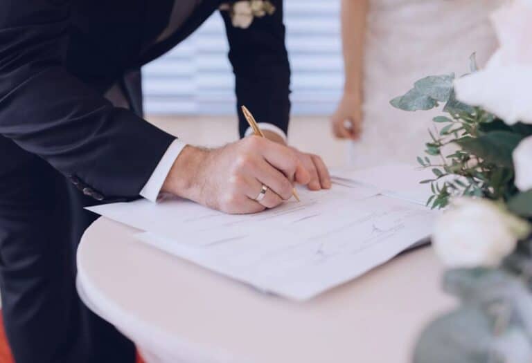 Uma imagem de um casal assinando documentos para casar.