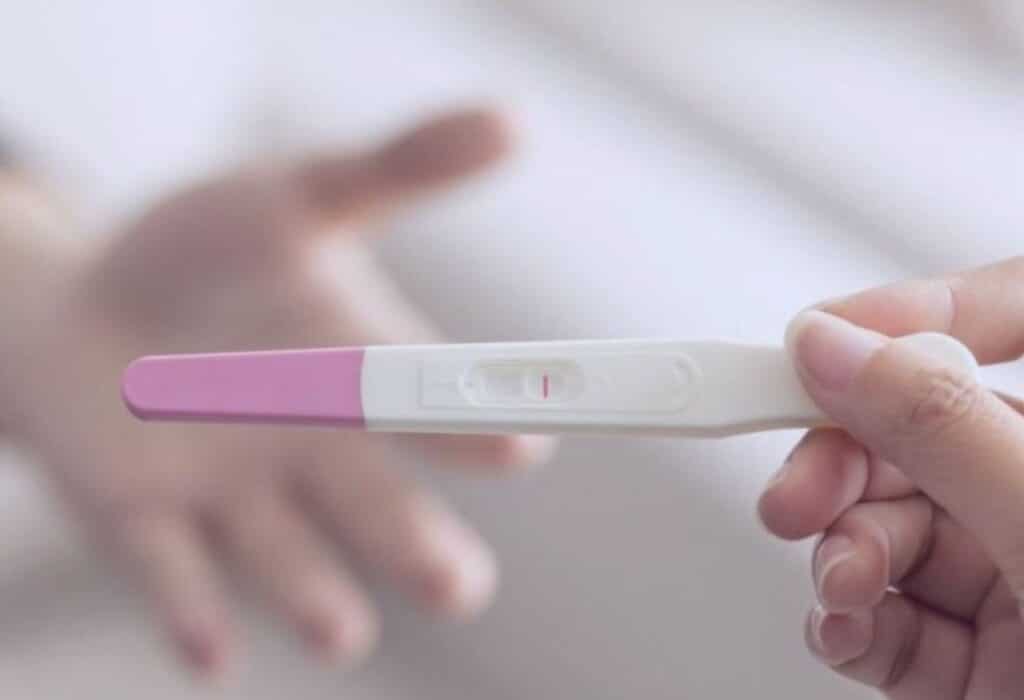 Uma imagem que ilustra uma pessoa segurando um teste de gravidez.
