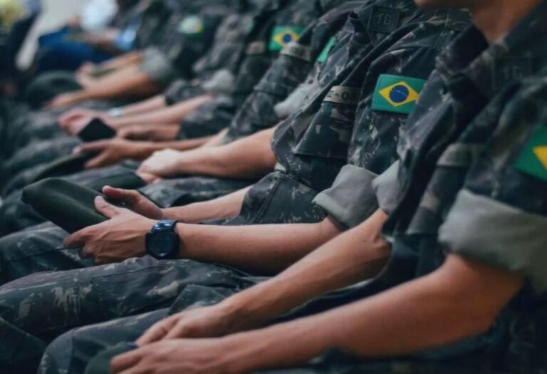 Uma imagem que ilustra homens uniformizados do exército sentado em filas.