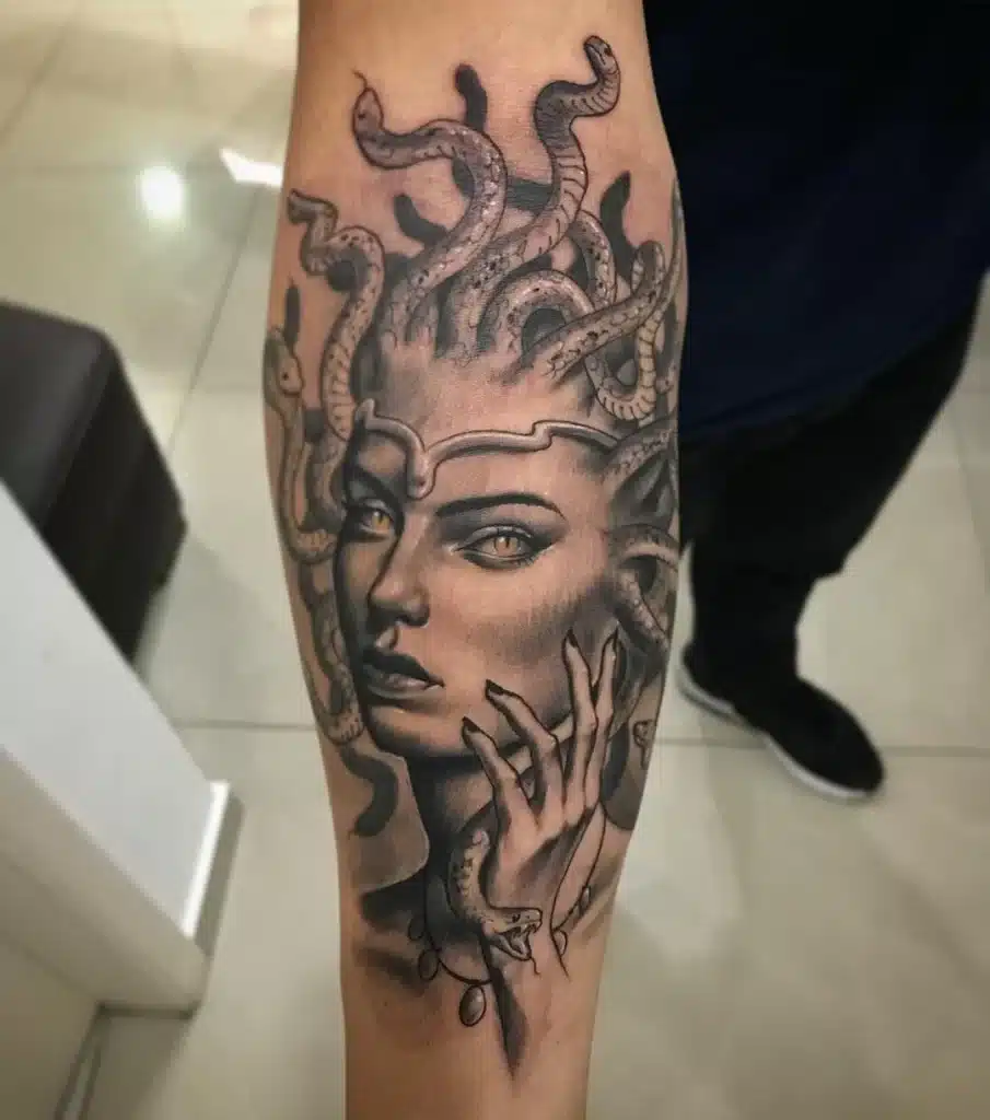 Uma imagem que ilustra uma tatuagem de medusa no braço.