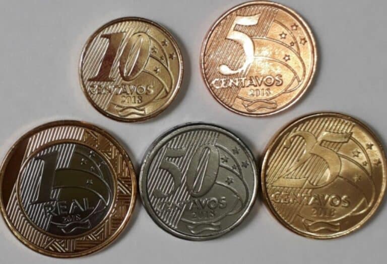 Uma imagem que ilustra vários centavos formando um real.