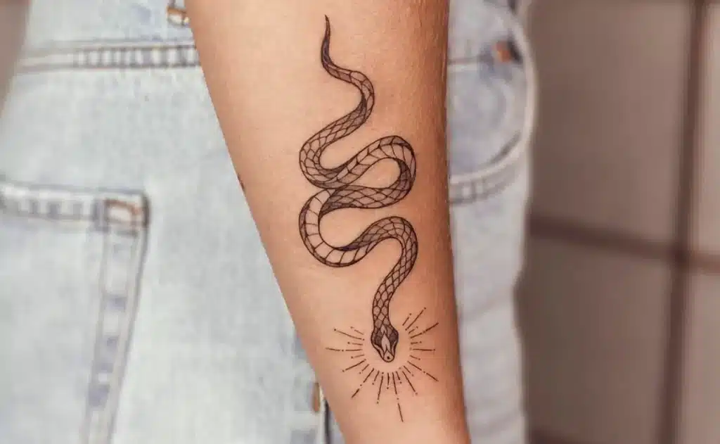 Uma imagem que ilustra uma tatuagem de cobra no braço.